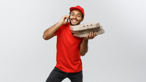 Entregador de iFood com caixas de pizza na mão e celular na orelha