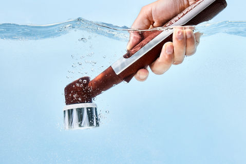 Action product photography of a brush underwater showing water movement and dynamic motion