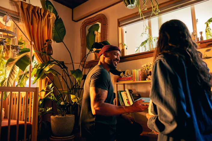 Lifestyle photography of a couple with a Chicco stroller at home reading kids’ books for advertising campaign