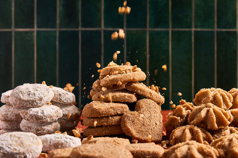 Action food photography of Romero Cookies crumbling in a stylized kitchen setup for advertising campaign