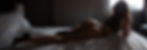 woman lying with back to the camer wearing a thong with the light highlighting the roundness of her butt cheeks