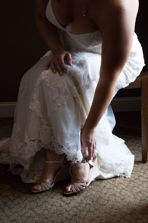 bride putting on shoes - 13 must have getting ready photos on your wedding day