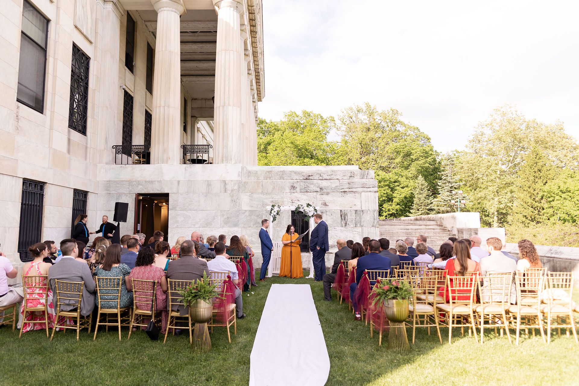 outdoor wedding ceremony next to Buffalo History Museum marble building with large pillars