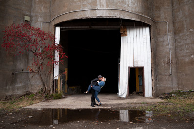 two women dip and kiss in front of open grain silo doors at silo city Buffalo