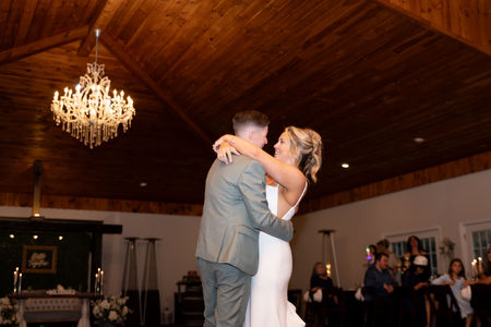 brides share first dance close up looking up at them with the wood ceiling and chandelier in background