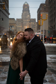 woman in dress and fur stohl leans back into man in suit