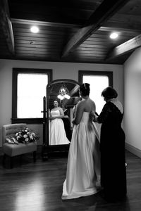 bride getting buttoned into dress by mom in bridal suite at brickhall clarence venue