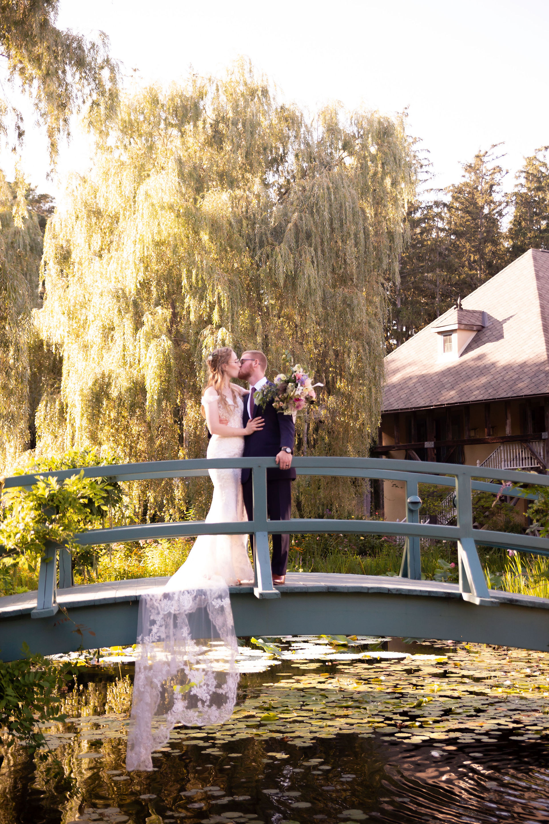 bride and groom on bride overlooking monet gardens at Mirbeau Inn and spa finger lakes wedding venue