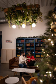 couple cozies up on a couch in front of a bookshelf with cocktails
