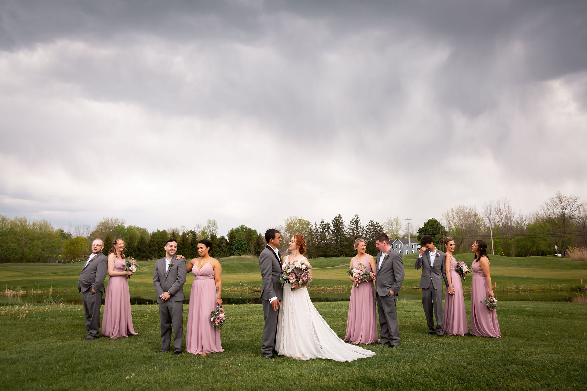 bridal party on golf course with stormy skies at Timberlodge in Akron NY