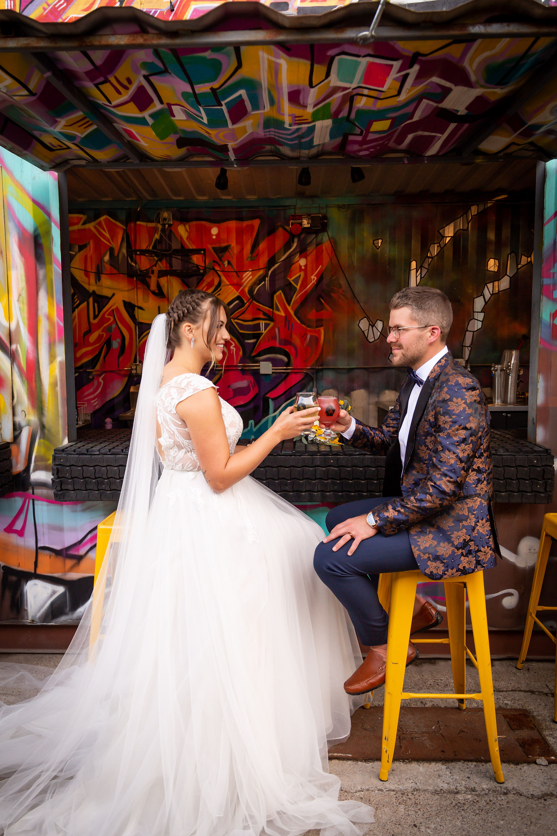 bride and groom cheers a beer in front of graffiti buffalo