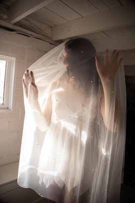 bride under wedding veil bathed in sunlight