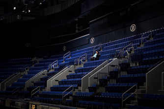 couple sits in a dark hockey arena alone snuggled up
