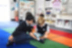 A 5th grade student reads with his first grade buddy at Saint Nicholas Catholic School