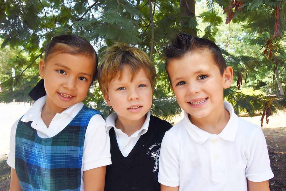This image links to the Planned Giving page. It depicts three kindergarten students, a girl and two boys, smiling as they play outside at Saint Nicholas Catholic School in Los Altos California.