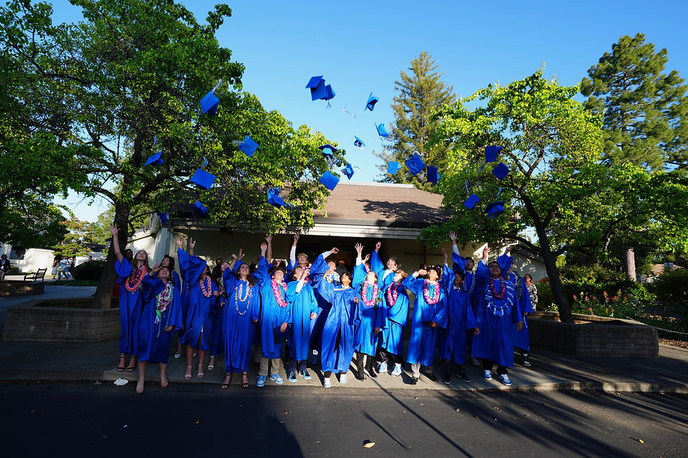 8th grade students toss their caps in the air after graduation from Saint Nicholas Catholic School