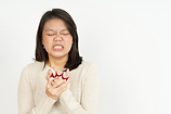 a woman grimacing while holding her hand