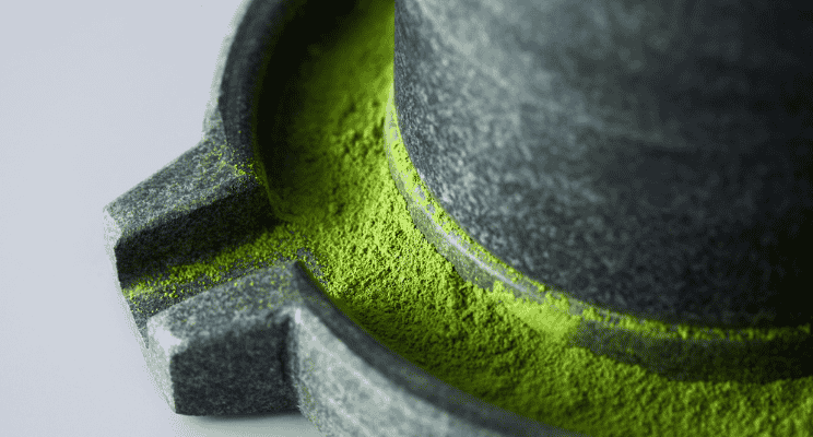 ground powder of green tea on a stone grinder