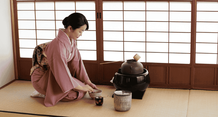 a teishu or tea master in japan holding a matcha ceremonial