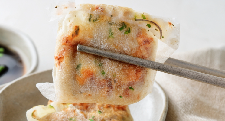 crispy dumplings held by a pair of chopsticks