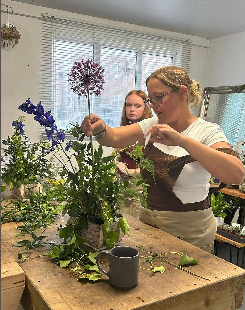 Beginner floristry students creating meadow style arrangements during a seasonal flower workshop at Bedfordshire Flower School