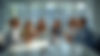 crea un'immagine realistica di persone contenti che parlano ad un tavolo in un ufficio di