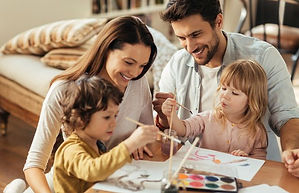 Fotografía de una familia compartiendo una actividad artística, símbolo de unión, colaboración y afecto. Representa los objet