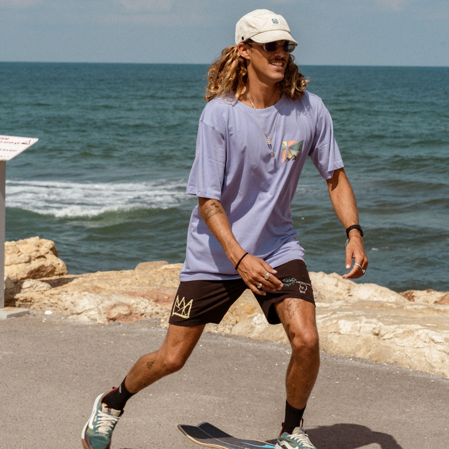 Man skateboarding near ocean wearing Surf Wagon Tee - Grey - Unisex