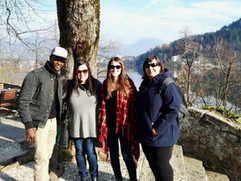 Four people smiling together near Lake Bled Slovenia with Julian Alps mountains in the background