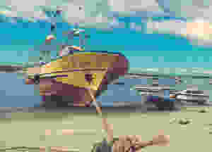 Large boat tied up on dry land close to water.