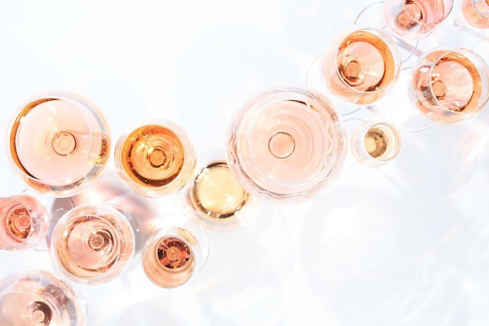 Overhead view of many glasses of rose wine at wine tasting.