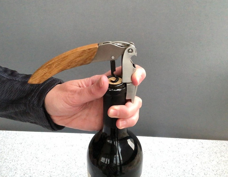 Wine Key showing how to press the first pull onto the rim of the bottle.