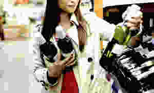 Woman deciding what wine to buy in a supermarket.
