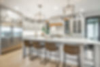 Interior modern farmhouse kitchen and dining room with white countertops bar stools large