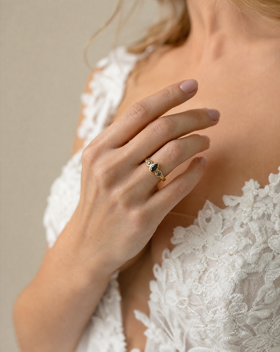 A raw engagement ring featuring a rough black diamond set in gold