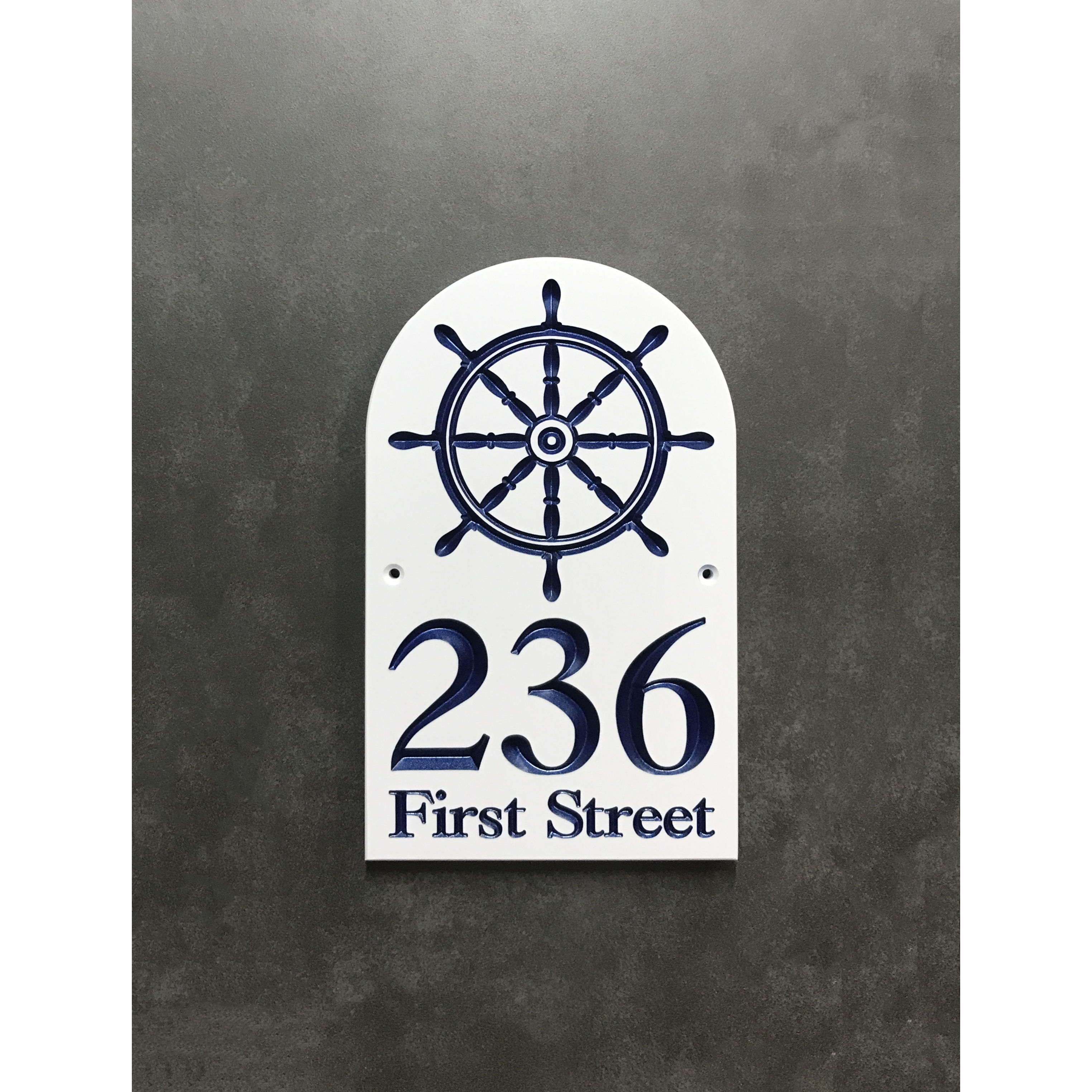 Maritime address plaque featuring V-carved house numbers on a weatherproof, stone-look solid surface material.