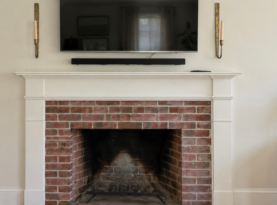Wide-angle view of a living room fireplace before a tile upgrade