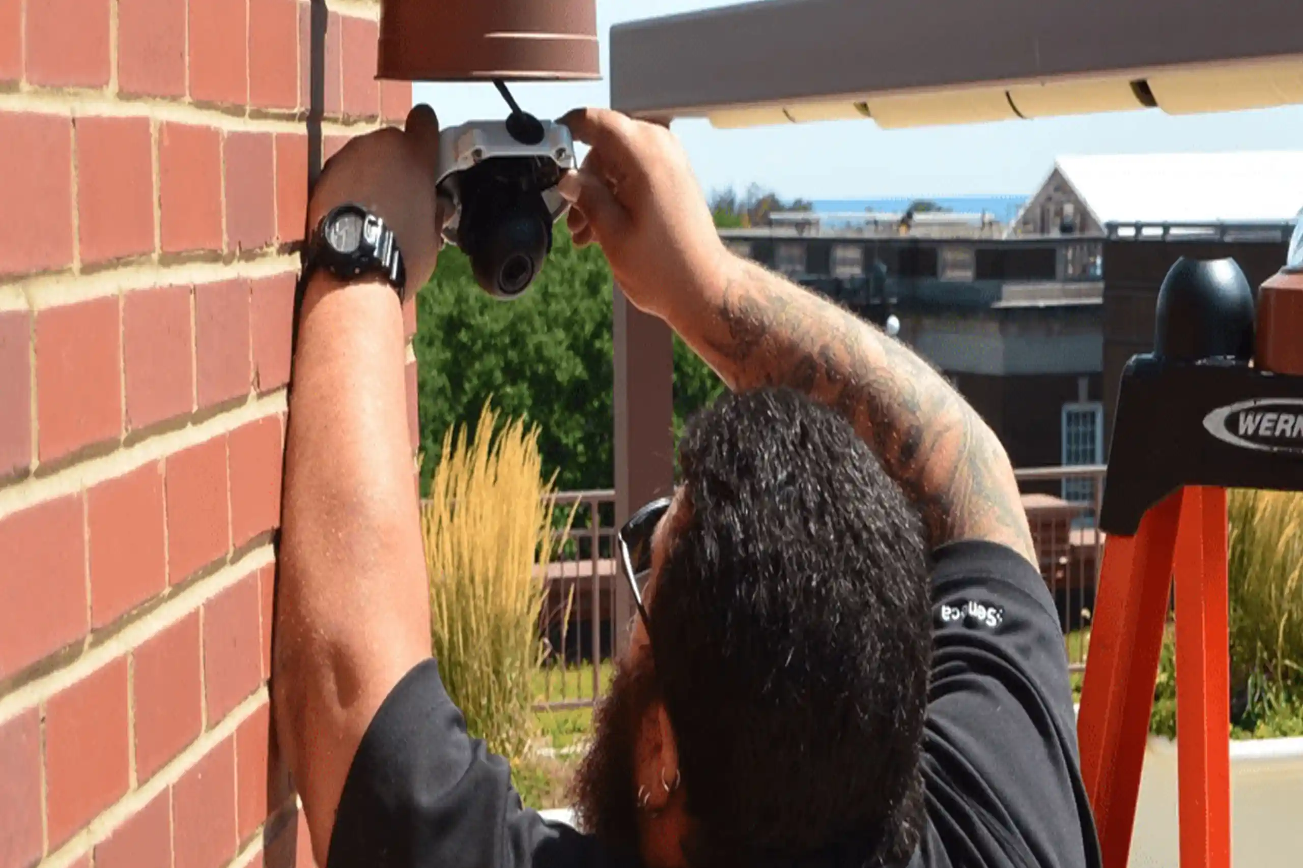 BTI security technician installing an Axis Security camera.