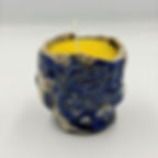 Bee Raku citrus candle in a blue textured ceramic pot