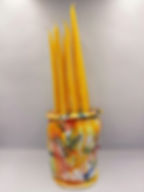 Yellow taper candles in a colorful splatter-paint ceramic jar