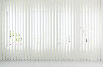 Large sliding glass door covered with modern fabric vertical blinds.