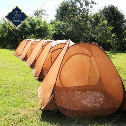 รีวิวภาพการกาง เต็นท์นั่งสมาธิ TM10-PP สีแก่นขนุน แบรนด์ต้นธรรม เรียงกันเป็นแถวยาวบนลานหญ้ากลางแจ้ง ท่ามกลางธรรมชาติ สำหรับใช้ในกิจกรรมธุดงค์หรือการปฏิบัติธรรมหมู่คณะ