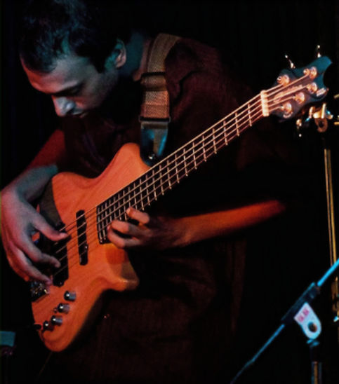 Sudarshan playing bass during a performance
