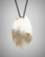 Back view of pink and white “jade” oval pendant showing flat back and soft green accents.