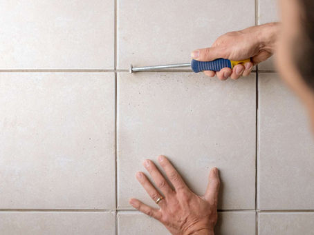 man regrouting ceramic tiles