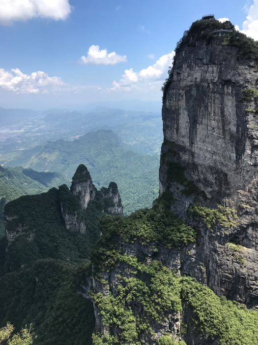Dramatic limestone peak rising above misty jungle valley