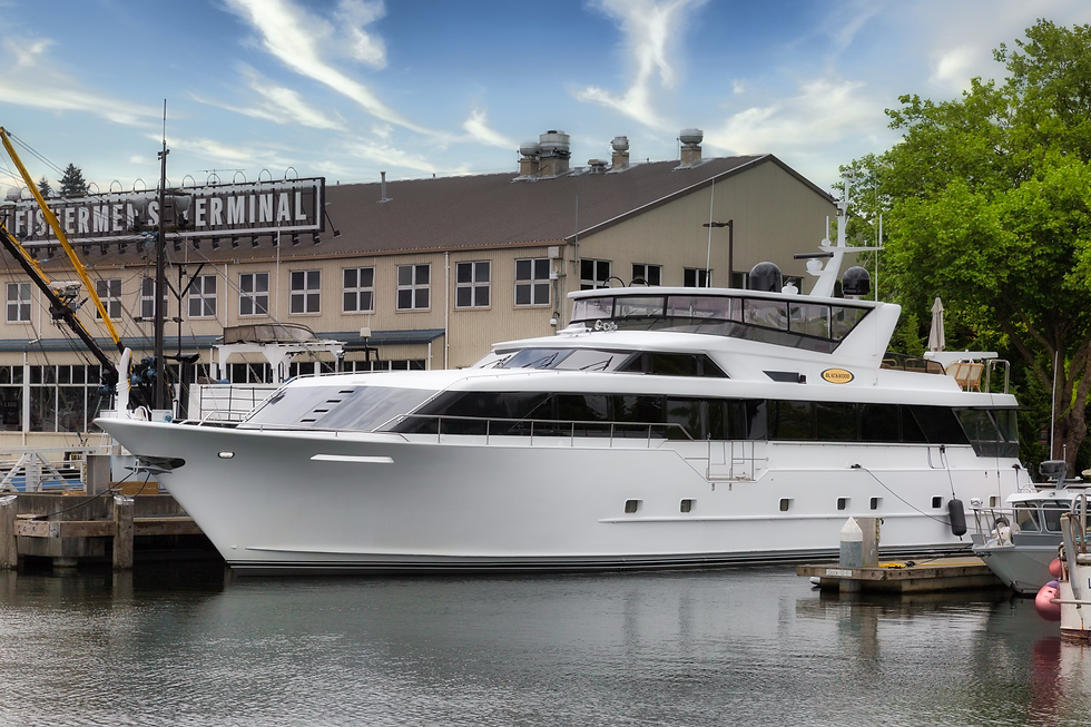 Full side view of Blackwood luxury yacht docked in front of a historic, elegant marina with beautiful architecture in the bac