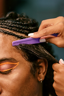 cornrow braids with stylist combing the hair