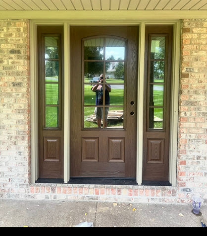 Wood-look entry door and matching sidelights in a brick opening during installation