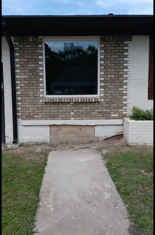 White-framed picture window set into a brick exterior